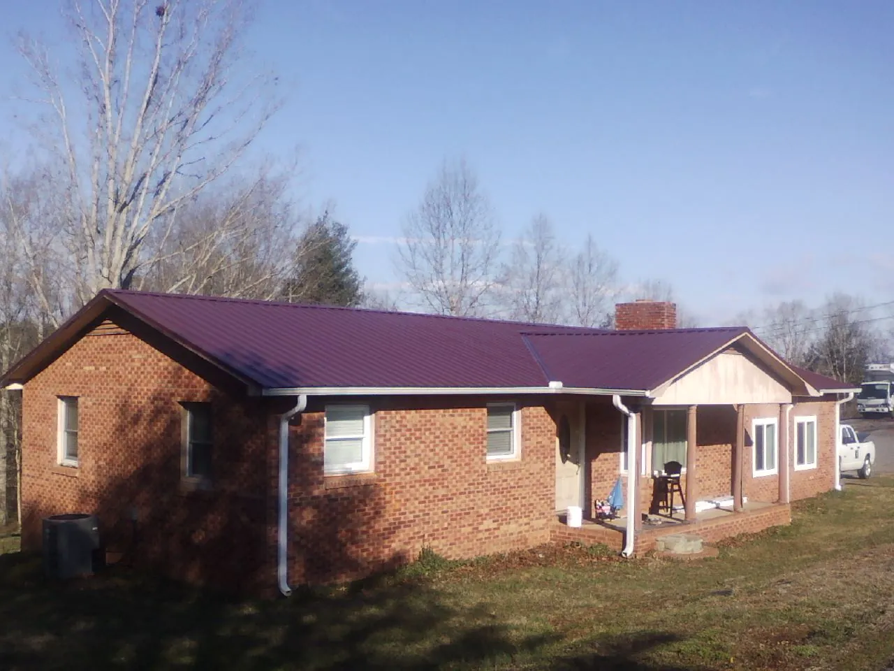 Burgundy metal roof on a brick ranch home with a new addition in Oakdale