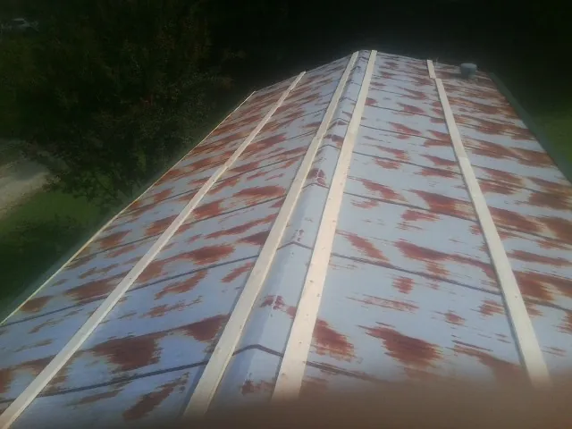 Rusted metal roof panels with new wood purlins before replacement — Storm Damage Roof Repair in Oakdale by Roofing Brothers