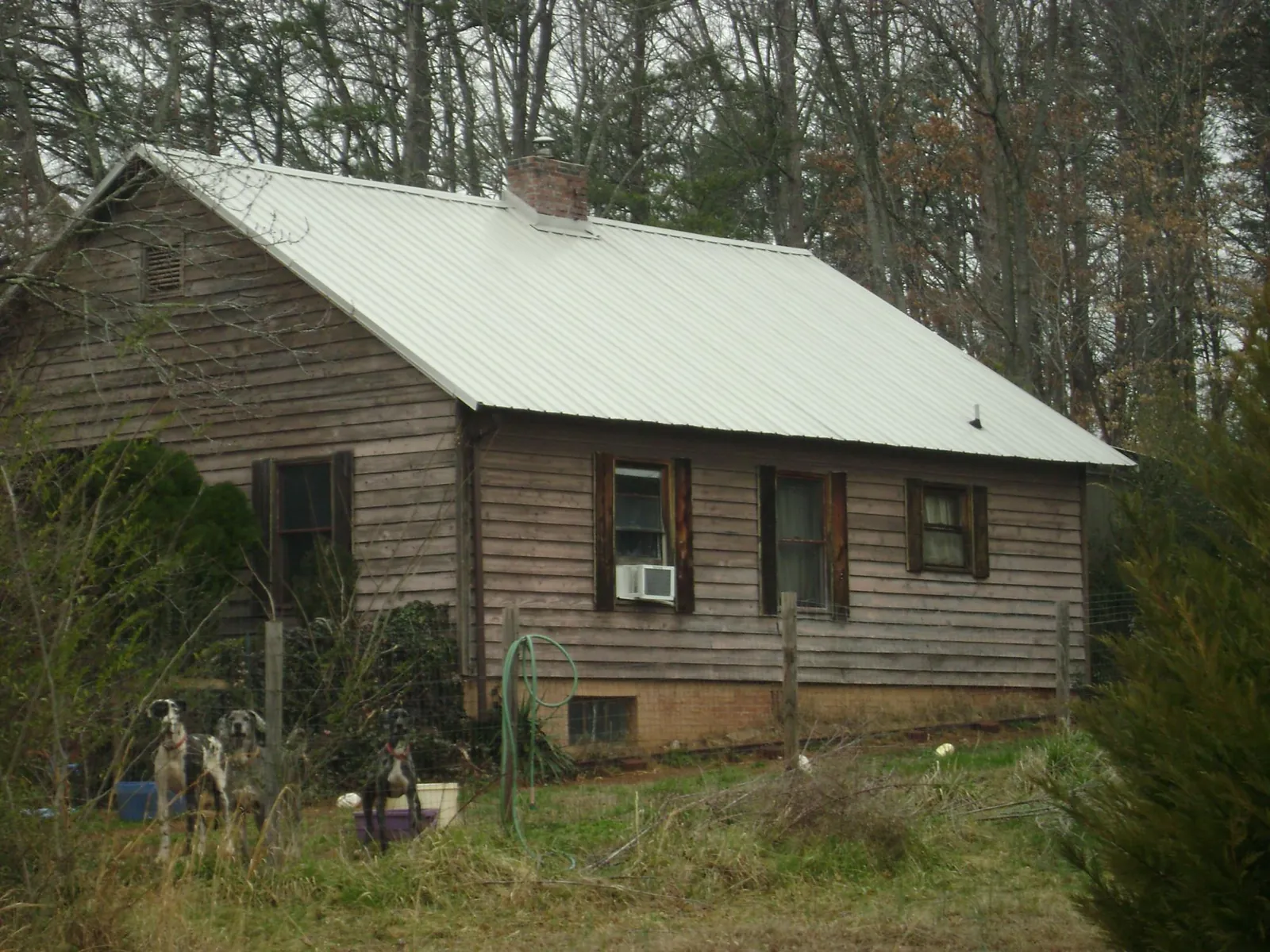 White metal roof on an old wood sided farmhouse, from a Metal Roof Installation job in Oakdale
